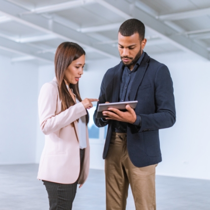 two business associates having a discussion while looking at a tablet device